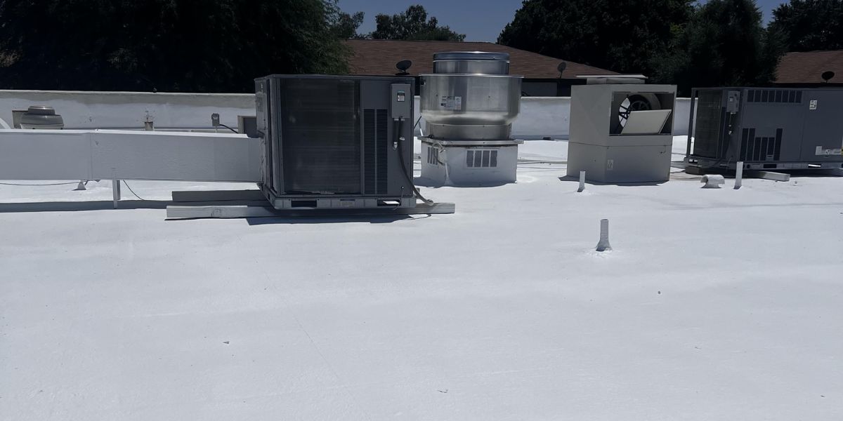 HVAC units and ventilation equipment on a commercial flat roof with new white coating in Arizona.